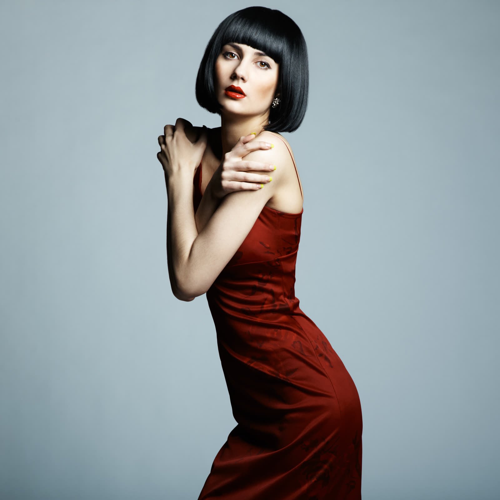 Woman with a black bob in a deep red satin dress