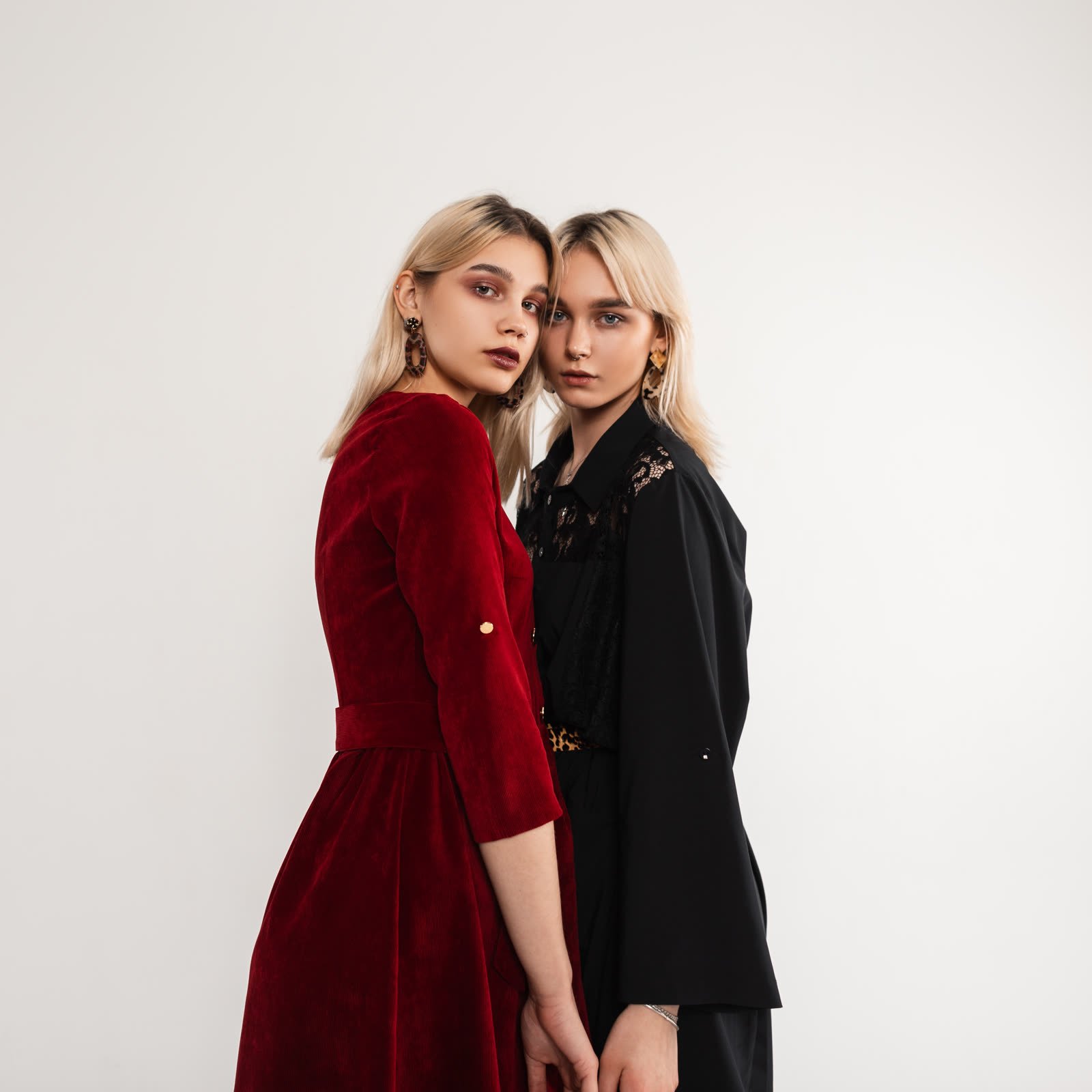 Two women side by side, one in a burgundy velvet dress and one in black